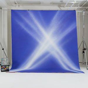 electric blue backdrop, light beam backdrop, graphic painted backdrop, editorial photo backdrop, bold fashion backdrop, stage light effect, crisscross spotlight, Oliphant Studio backdrops